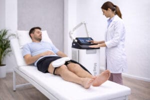 Paciente en camilla recibiendo estimulación magnética periférica MagRex en una clínica de fisioterapia
